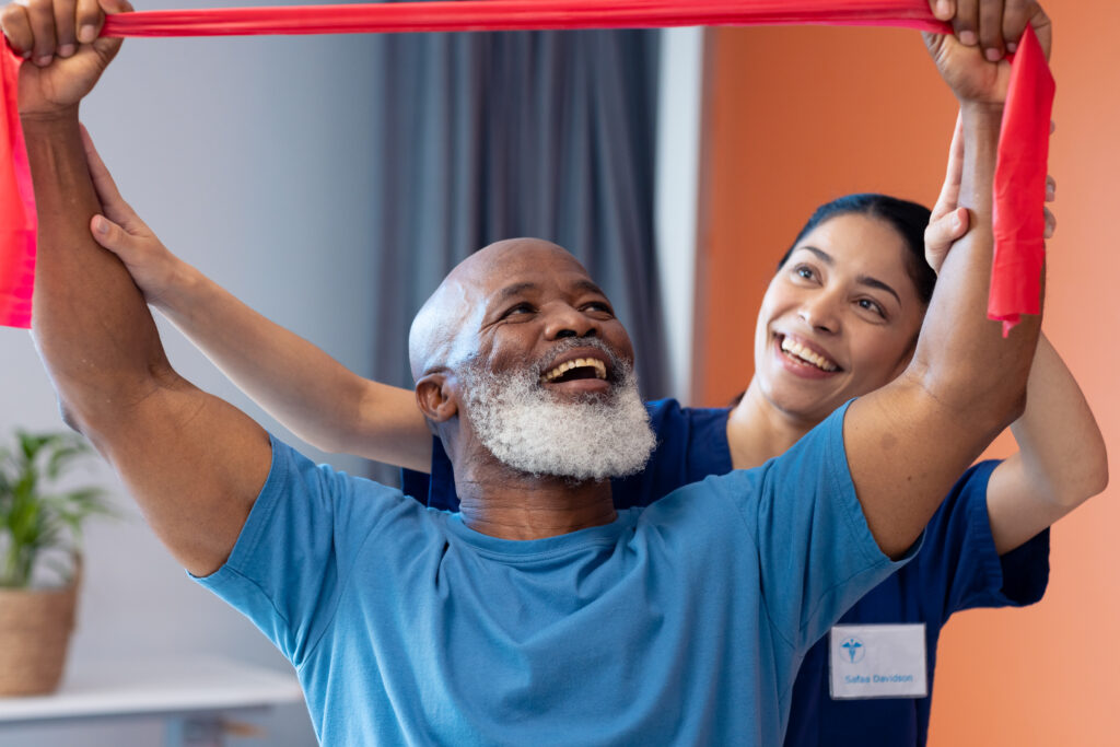 What to expect at physical therapy: a senior African American man does physical therapy with a female doctor.