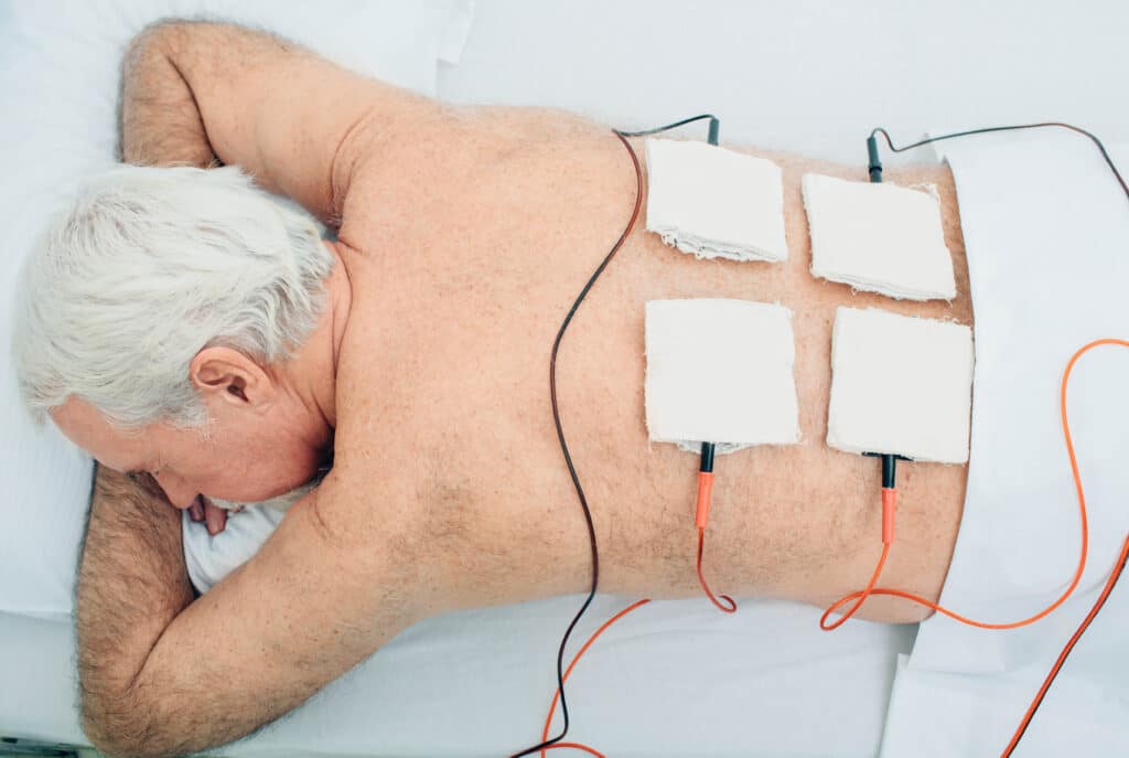 Image of an older man receiving EST for back pain