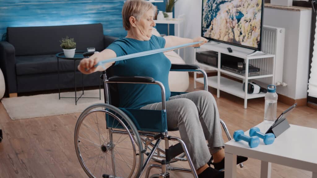 Telerehabilitation in Physical Therapy: a woman in a wheelchair follows her physical therapy program on her tablet