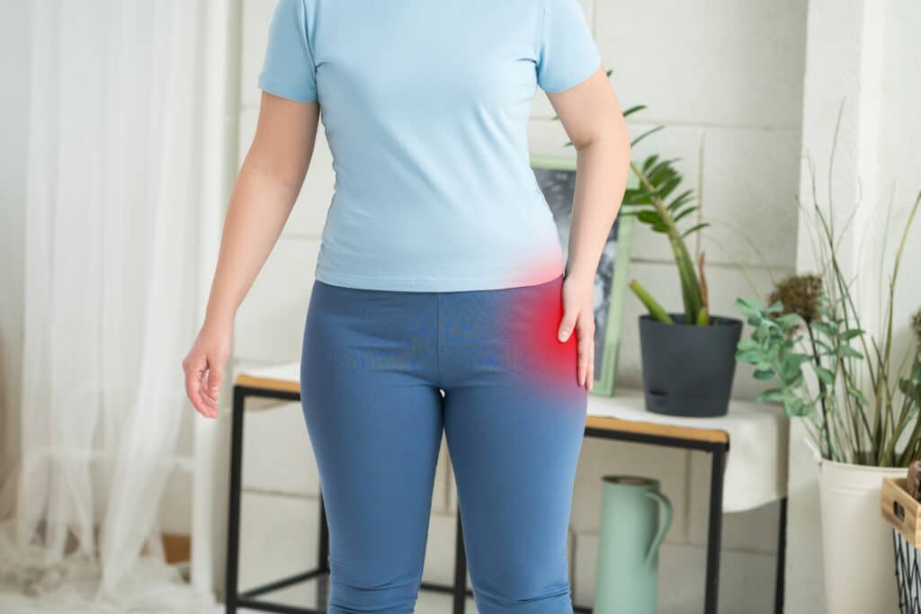 Exercises for hip bursitis: Image of an older woman holding a painful area on the side of her hip