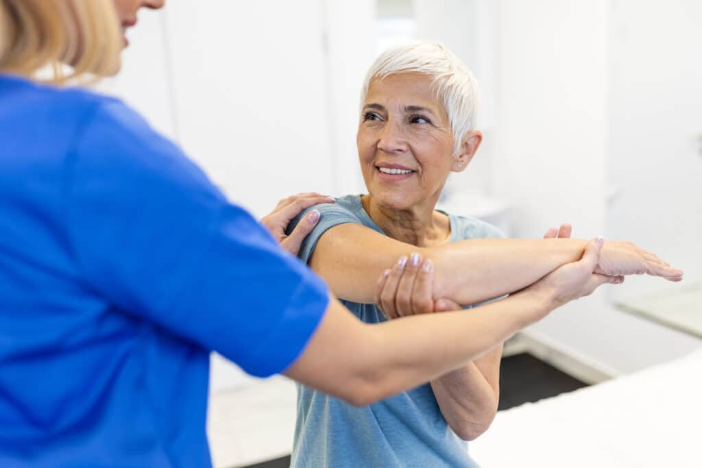 Image of a senior woman doing physical therapy for arthritis in her shoulder