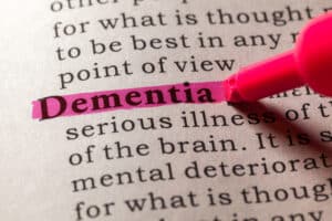 Image of the word dementia highlighted in a dictionary. Exercise is one of many treatments to dampen the effects of dementia.
