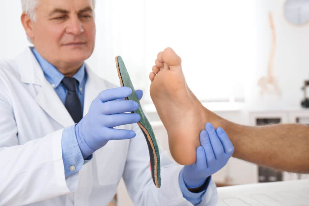 Image of a doctor fitting his patient for custom shoe orthotics