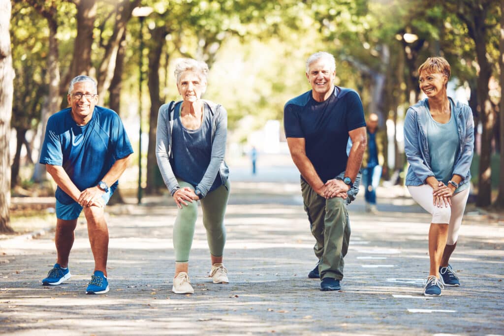 Best Walking Stretches for Seniors: Seniors stretching together as they prepare for a jog outdoors