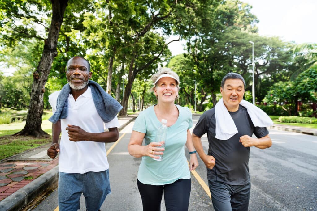 Image of senior friends jogging outdoors to improve physical and cognitive benefits through exercise