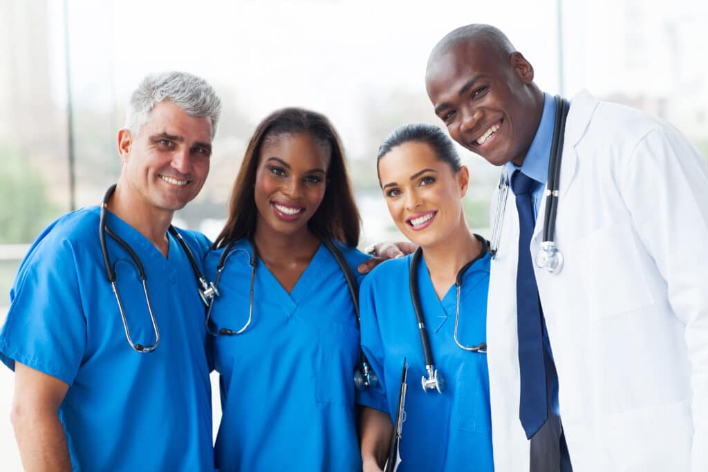 Image of a team of doctors, nurses, occupational and physical therapists in a hospital setting in scrubs.