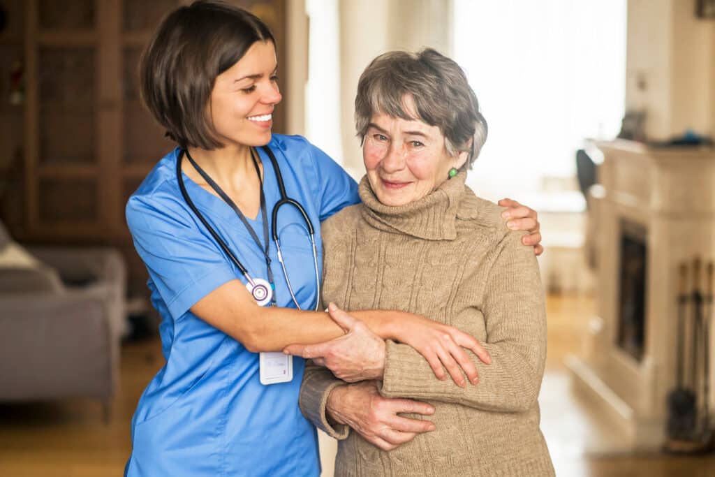 Older Senior woman with dementia getting caring treatment from younger physical therapist