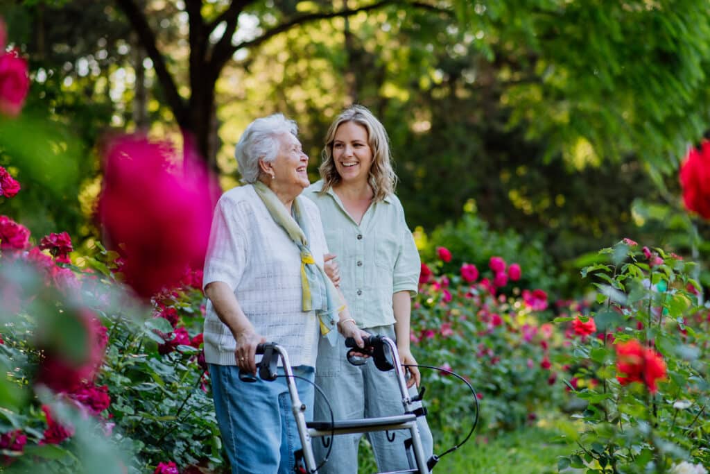 PhysioEd guide to Choosing your first walker. Image: senior woman with her walker in the park with her adult daughter