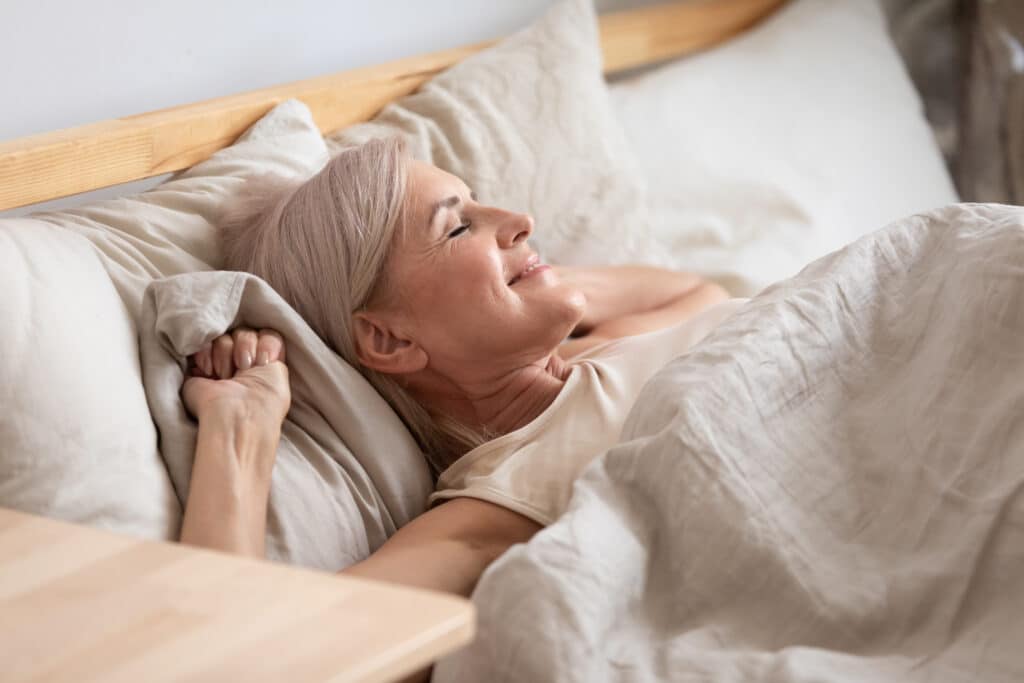 Image of a senior woman waking up well-rested after a good night's sleep—a key element of a healthy lifestyle for seniors