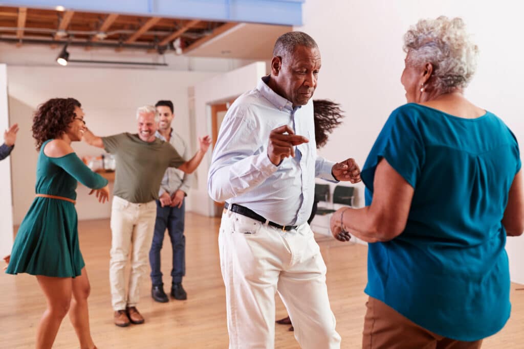 Image of seniors in a community dance class.  Exercising with friends is a great way to reap the cognitive benefits of exercise.