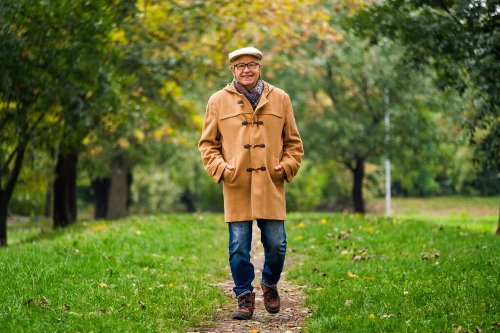 How to Improve Balance and Prevent Falls: A senior man walks by himself outdoors in the autumn