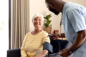 Image of a senior woman getting her blood pressure reading from a male nurse