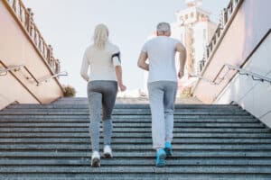 Image of healthy senior couple jogging up a flight of stairs