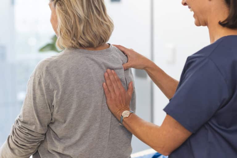 An older female gets screened by a doctor for degenerative scoliosis