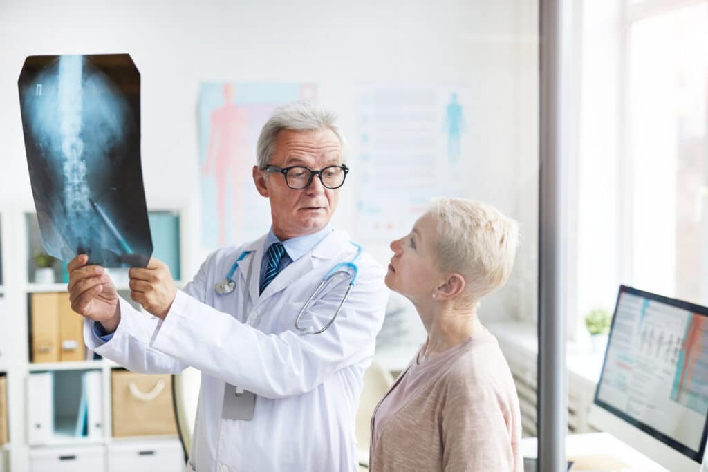 Image of a doctor explaining spinal fusion to a senior female patient.