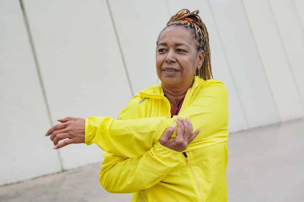 An active senior African American woman stretches before a workout.