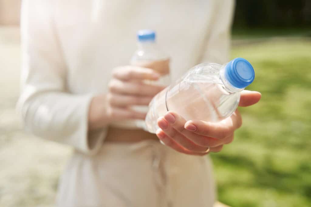 Plastics in the body: a woman holds two plastic water bottles.
