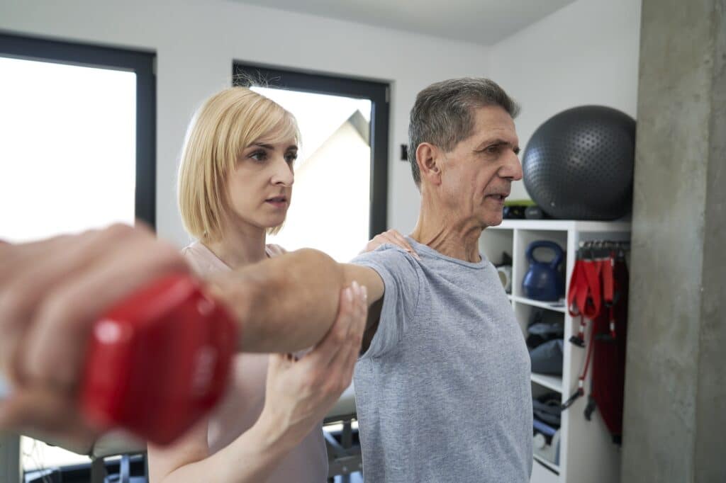 Female physical therapist working with senior man