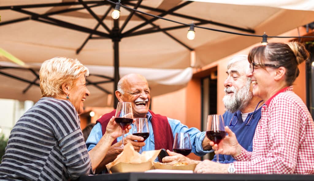 Seniors having dinner and wine outdoors without bladder spasms