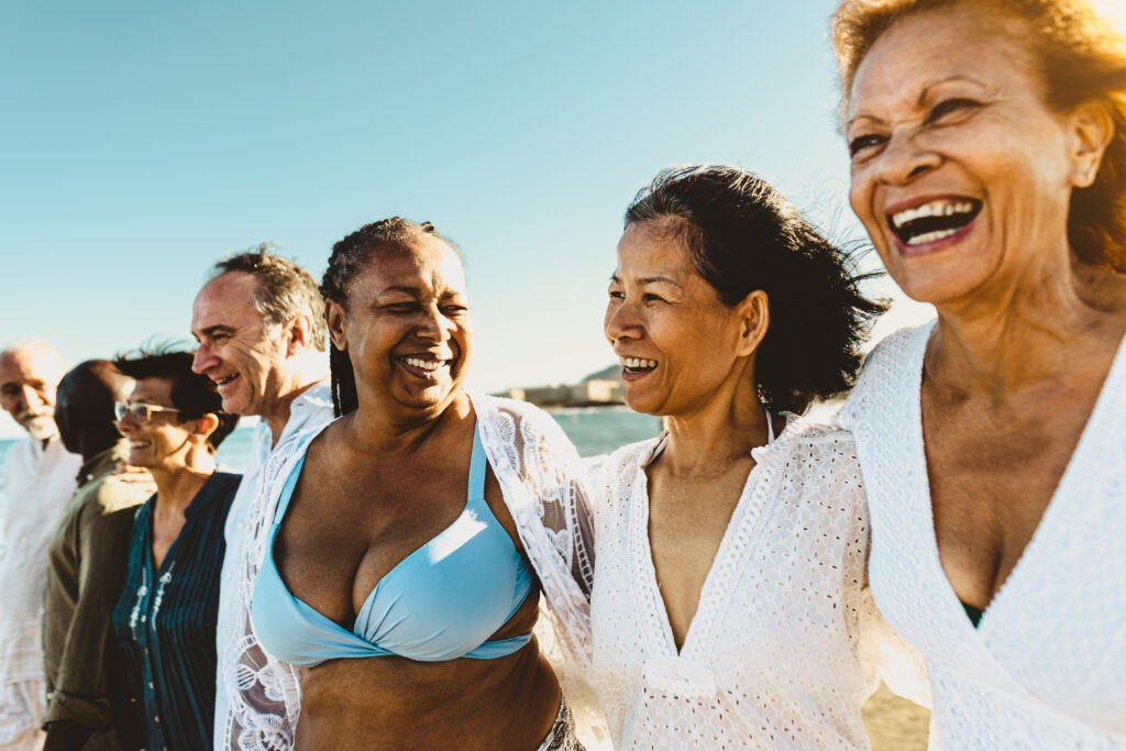 A group of senior friends having fun together at the beach.
