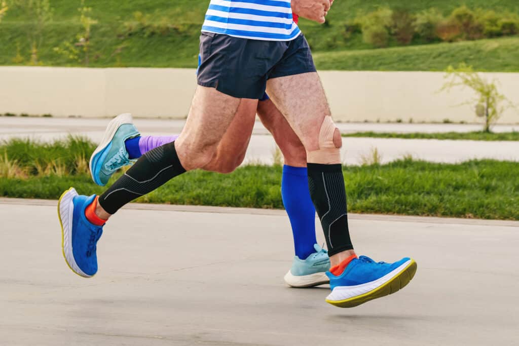 Image of two senior men running with compression socks
