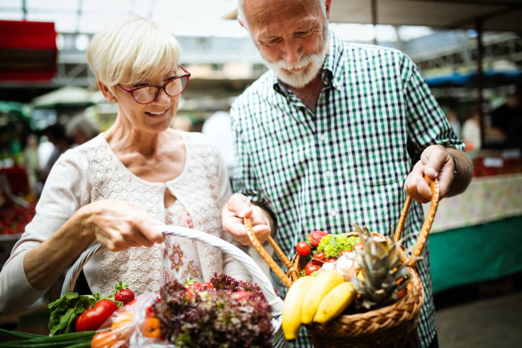 Improving Bone Health for Surgery: A senior couple shops for vegetables at the supermarket