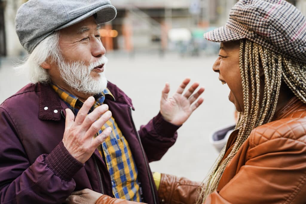 Two senior friends having a friendly conversation outdoors