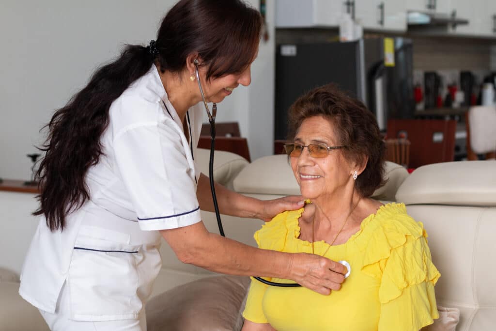 Aging in place: a senior woman receives a checkup from a home health care aide.