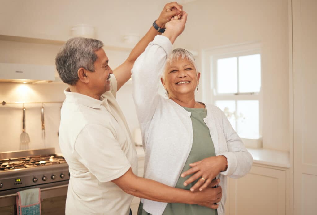 The Best Hip Exercises for Seniors: a senior couple dances happily in the kitchen