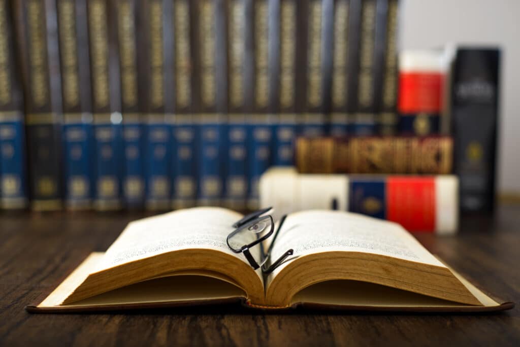 Image of a dictionary with a pair of glasses on a desk