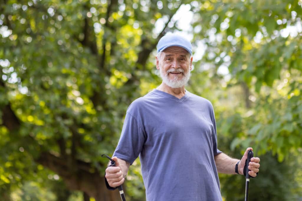 Assistive Tools for Parkinson's Disease: A man with PD uses trekking poles in the park