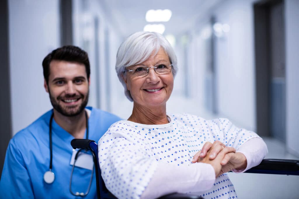 Senior female patient smiling with her PT during phase one recovery from coronary artery disease