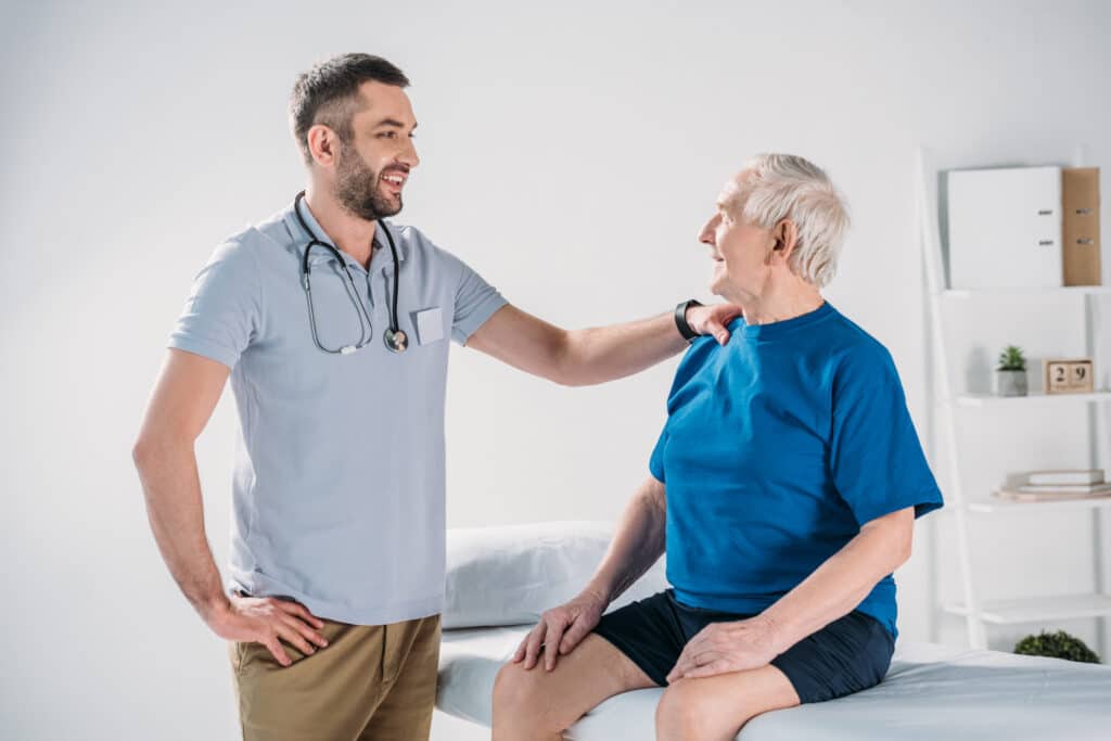 A physical therapist chats with a senior patient: Physical therapy is a fundamental piece of cardiac rehab