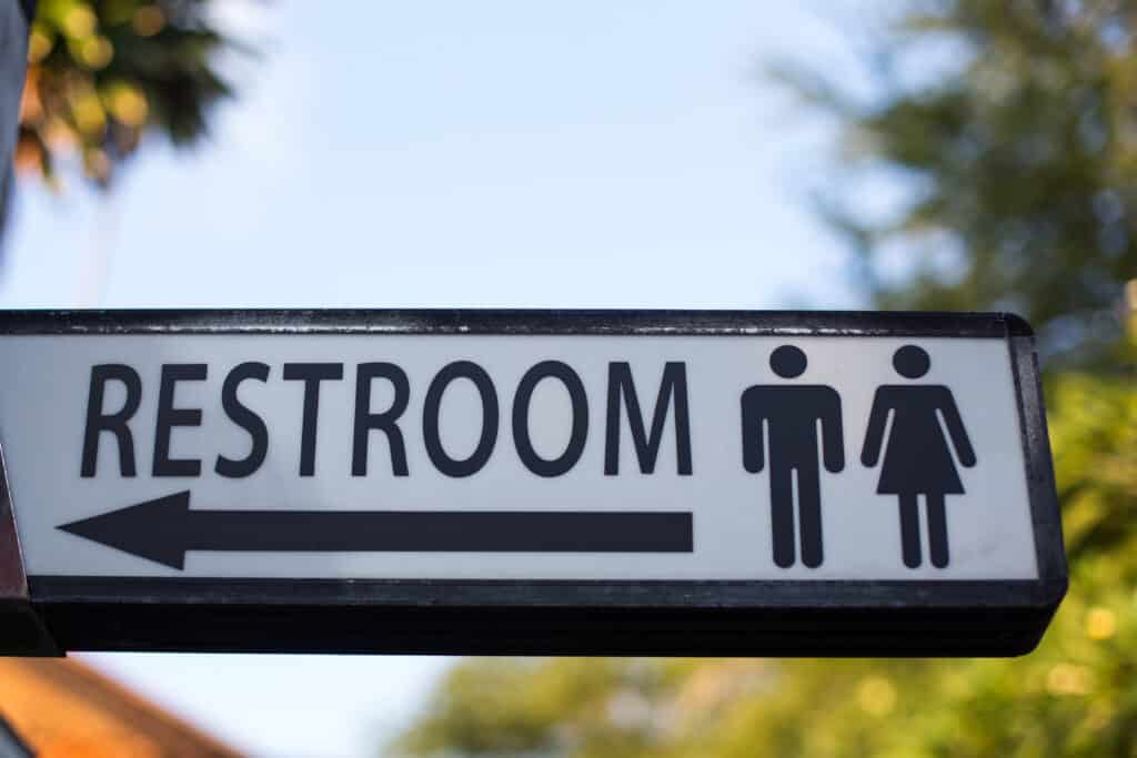 Restroom sign outdoors for seniors with stress urinary incontinence.