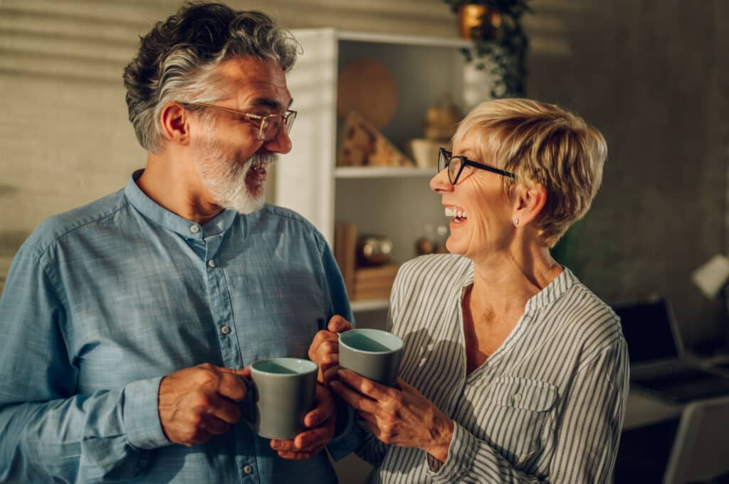 Senior couple drinking morning coffee together at home