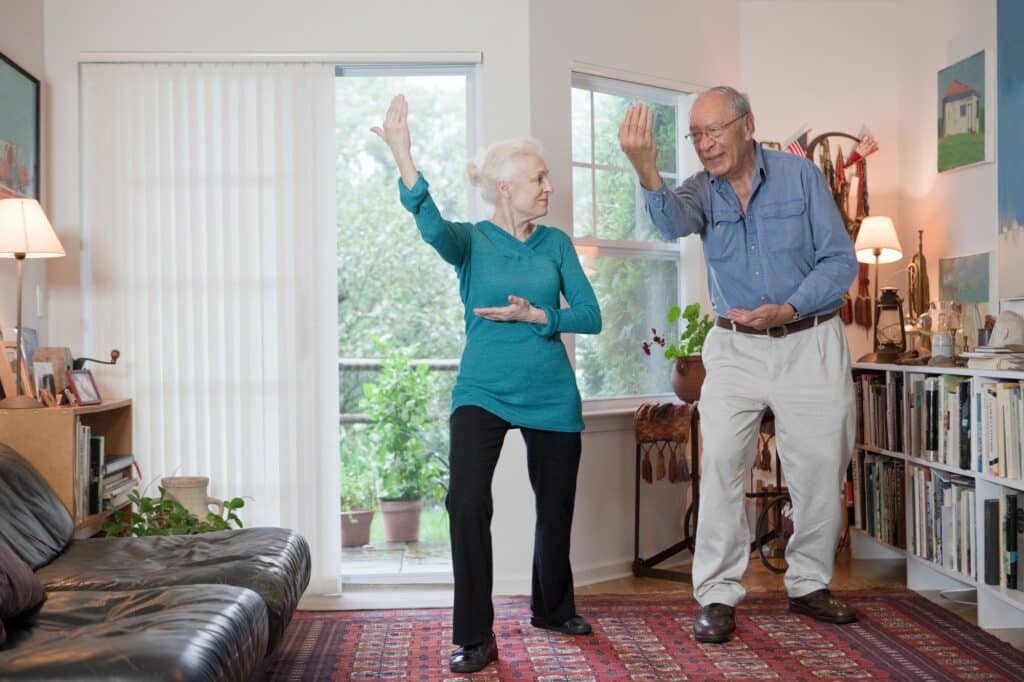 Couple performing qigong in living room