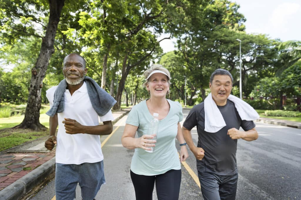 When to start exercising after covid: senior friends running outdoors.