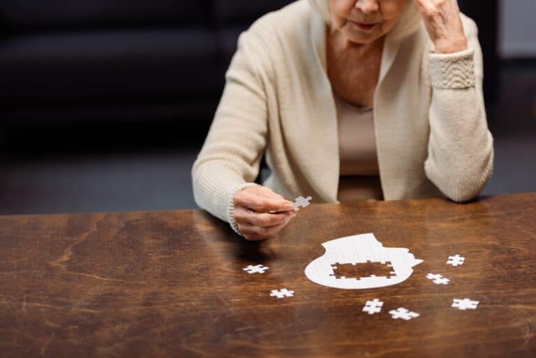 senior woman collecting jigsaw puzzle as dementia therapy
