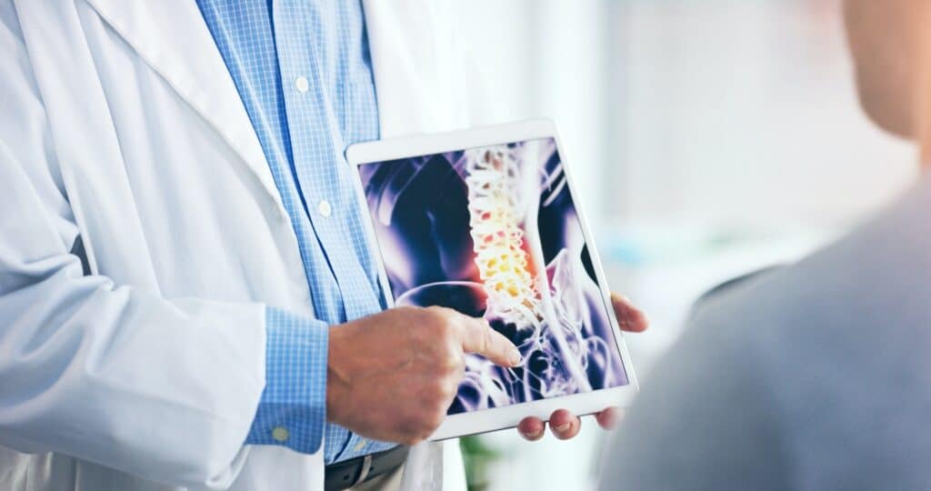 Image of a doctor with an ipad explaining back pain 
