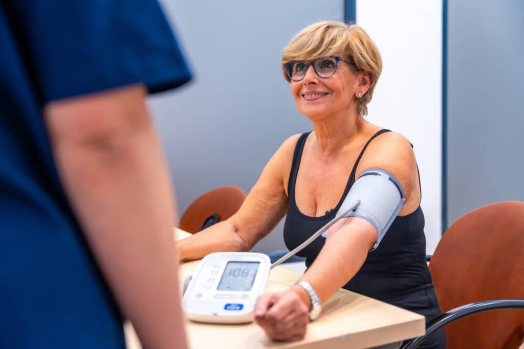 Image of an older woman checking her blood pressure at a clinic. 
Maintaining healthy blood pressure is an important part of stroke prevention.