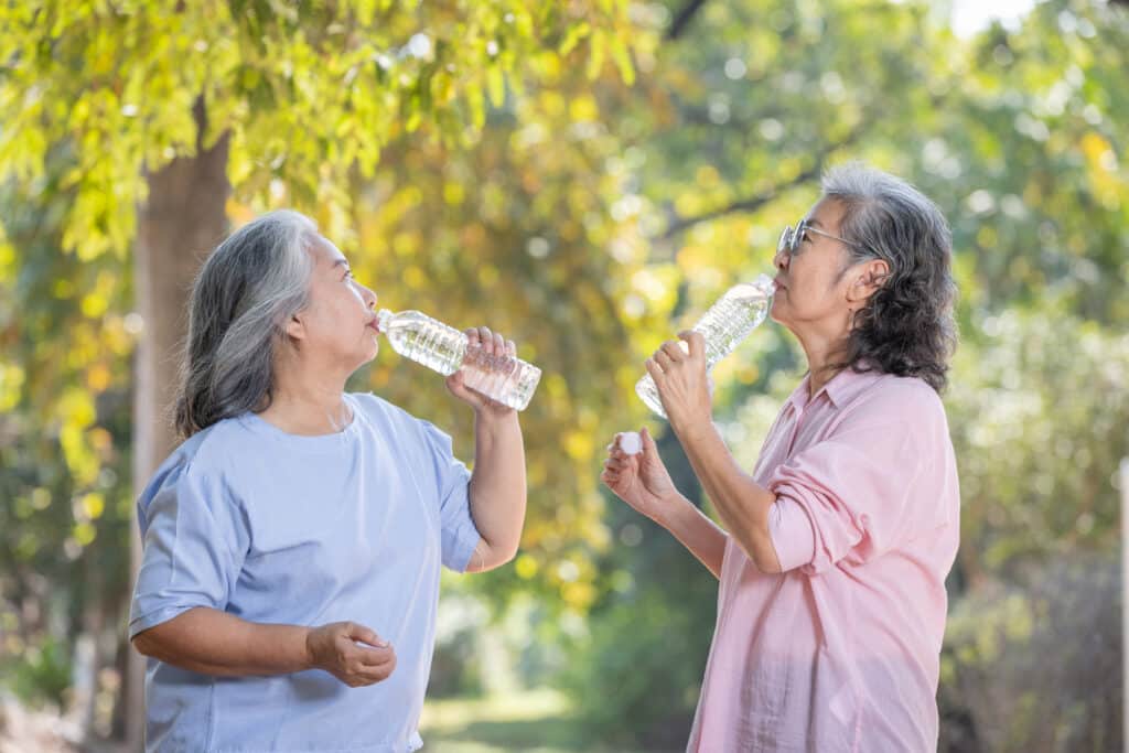 When to start exercising after covid: senior women drinking water after covid