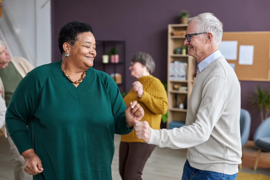 Seniors dancing at a senior center to practice cognitive exercise in a fun physical environment